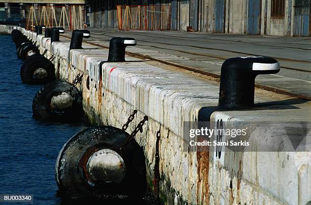 bollards and tires at dock - nautische ausrüstung stock-fotos und bilder