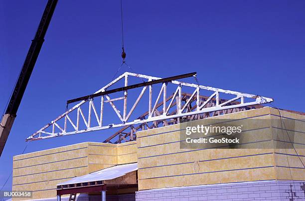 wood truss being placed in position - roof truss stock pictures, royalty-free photos & images
