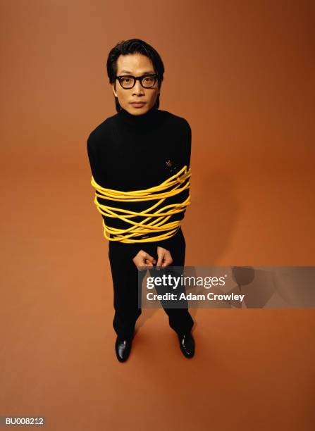 businessman tied up with power cord - gebunden stock-fotos und bilder