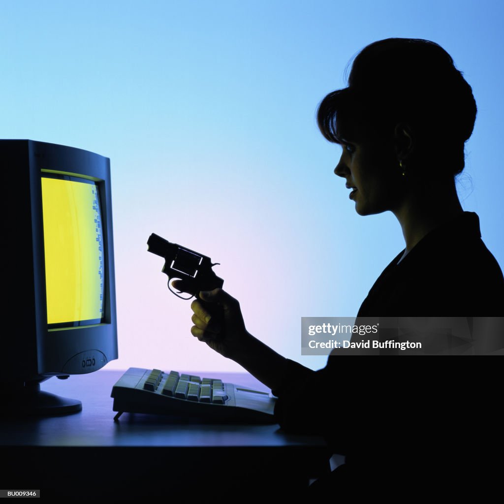 Silhouette of Businesswoman Shooting at Computer