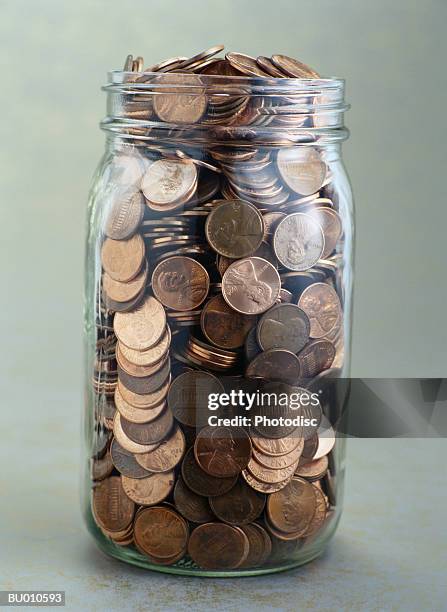 jar of pennies - saving up for a rainy day stock pictures, royalty-free photos & images