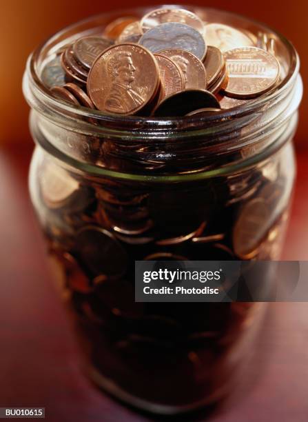 pennies in a jar - saving up for a rainy day stock pictures, royalty-free photos & images