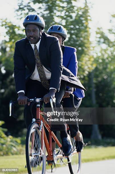 businesspeople riding a tandem bicycle - tandem bicycle foto e immagini stock