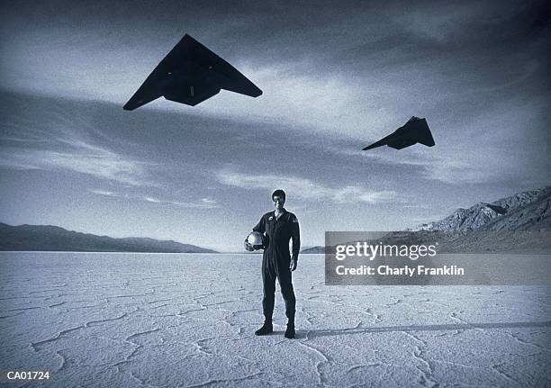 pilot in desert, stealth bombers flying over (b&w) - flight suit stock pictures, royalty-free photos & images