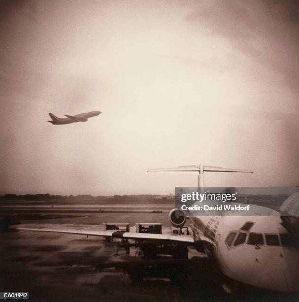 aeroplane hangar, jet taking off in background (toned b&w) - waldorf stock-fotos und bilder