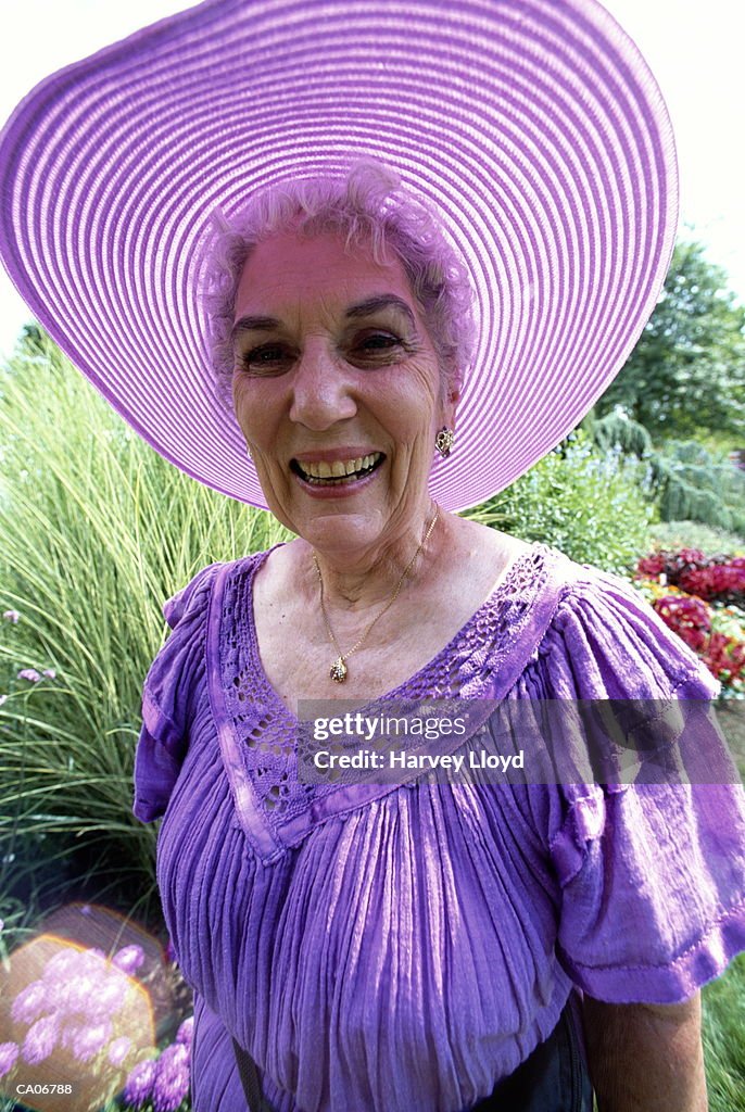 Mature woman wearing purple dress and hat, portrait