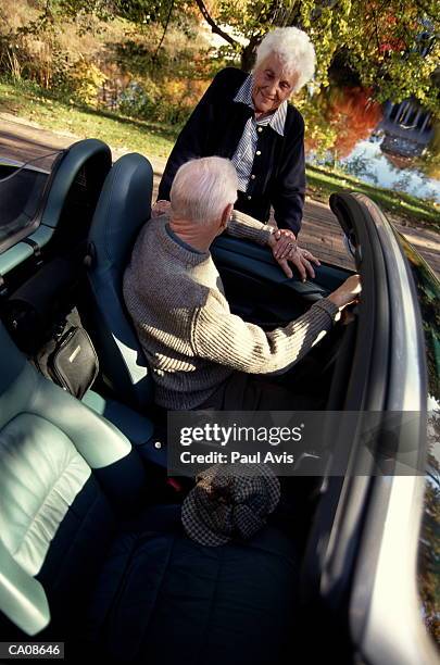 elderly woman talking to elderly man in sports car, elevated view - ['sports car' stock pictures, royalty-free photos & images