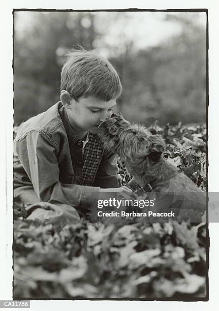 dog licking boy's (8-10) face in autumn (b&w) - kid face dog lick fotografías e imágenes de stock