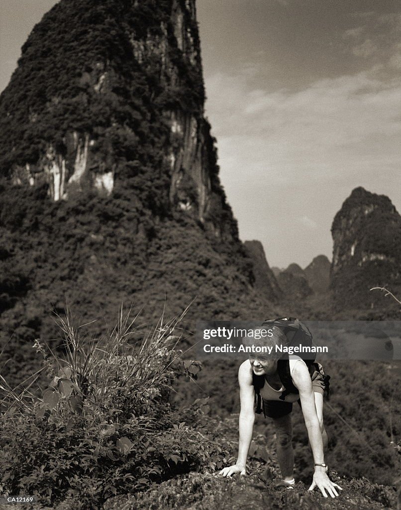 China, Guilin, woman hiking in mountains (B&W)