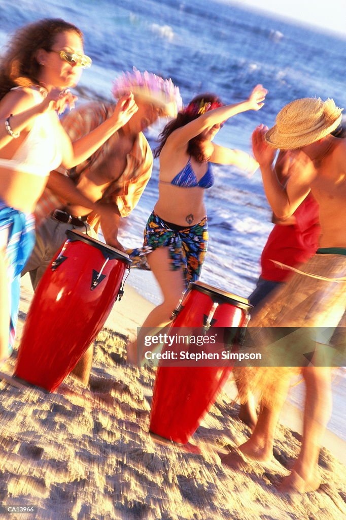 FRIENDS PARTYING AT THE BEACH MEN PLAYING DRUMS