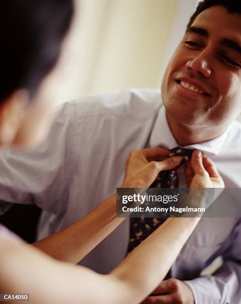 woman adjusting man's neck tie - zondagse kleren stockfoto's en -beelden