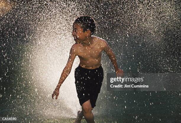 boy (5-7) playing in sprinkler - cummins stock pictures, royalty-free photos & images