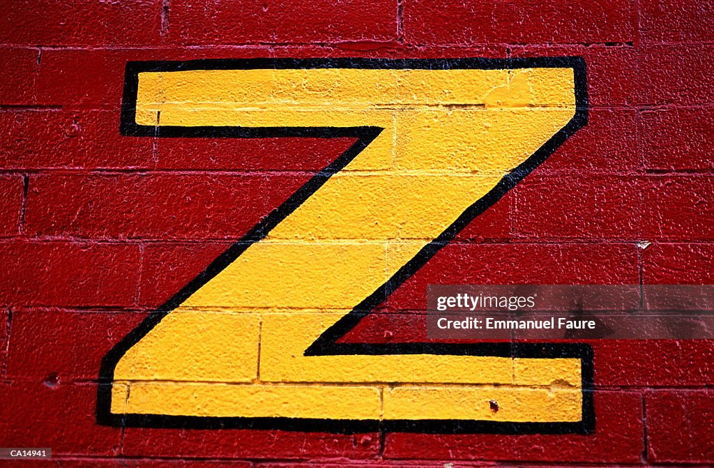 Letter 'E' painted on brick wall, close-up