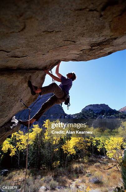 male rock climber scaling overhang - rock overhang stock pictures, royalty-free photos & images