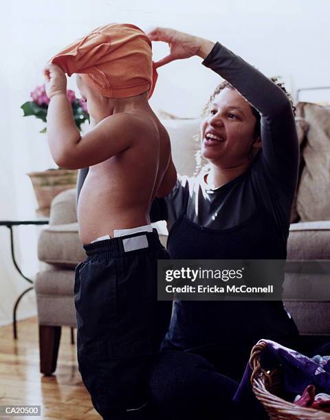 african american mother dressing son, original - ericka stock pictures, royalty-free photos & images