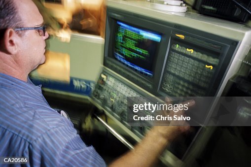 Worker using computer programmed lathe (blurred motion) Worker using computer programmed lathe (blurred motion)