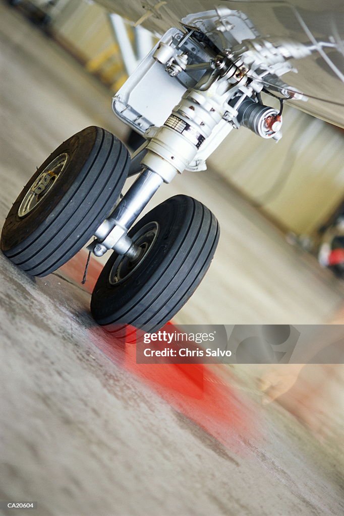 Wheel chocks being pulled away from plane in hangar (blurred motion)