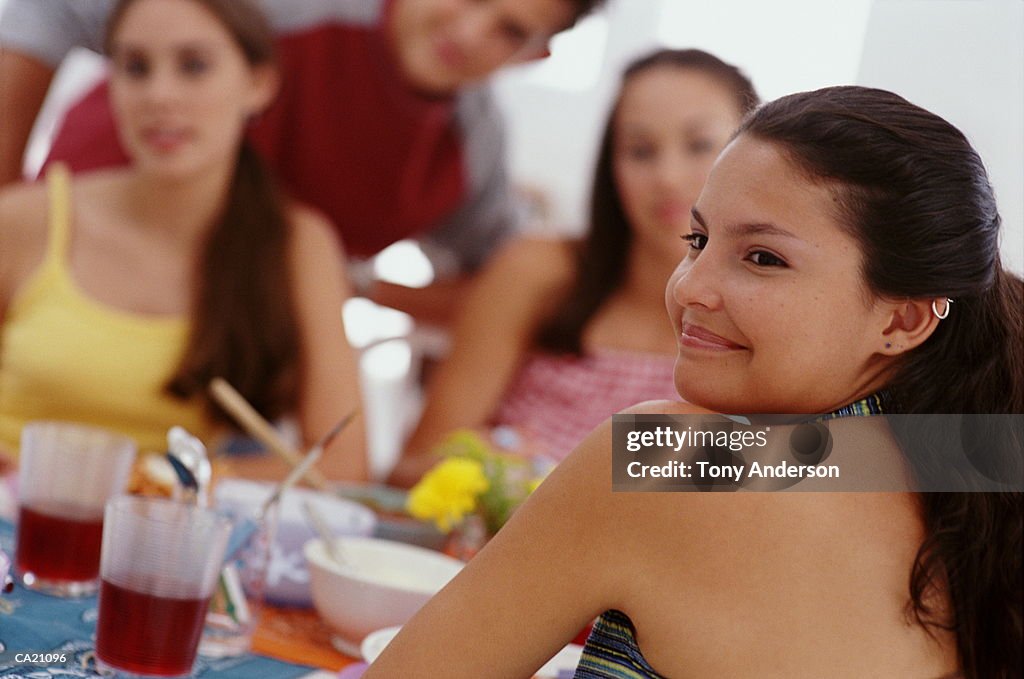 Multi-racial teenagers (14-16) sitting at dinner table