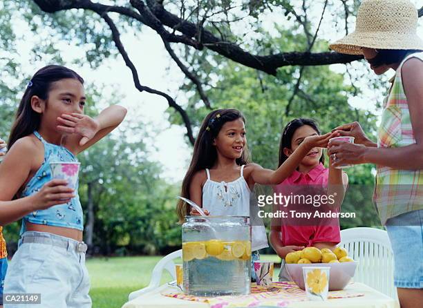 girls (6-8) selling lemonade on lawn - buvette photos et images de collection