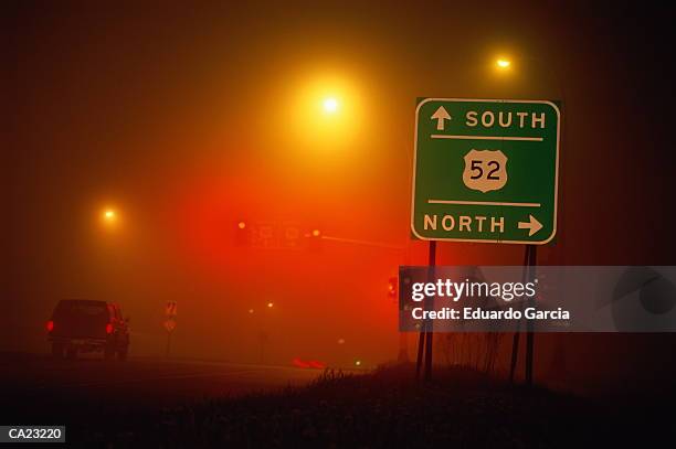 road signs in fog at night minnesota - garcia stock-fotos und bilder