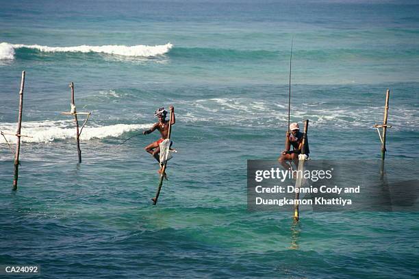 sri lanka, ahangama, men fishing from stilts fixed in ocean bed - general economy as central bank of sri lanka looks to contain rising inflation stockfoto's en -beelden