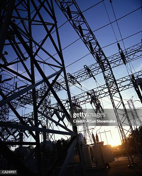 high voltage power lines at power station, sunset, low angle view - high and low stockfoto's en -beelden