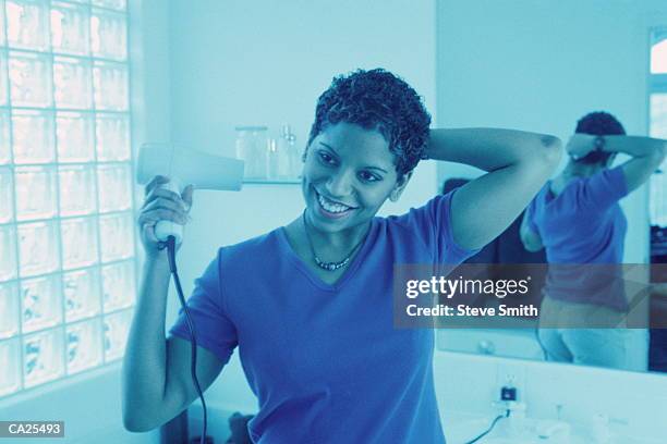 young woman drying hair in bathroom (cross-processed) - cross processed imagens e fotografias de stock