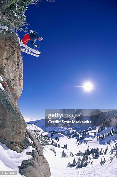 skier leaping from cliff - alta stock-fotos und bilder