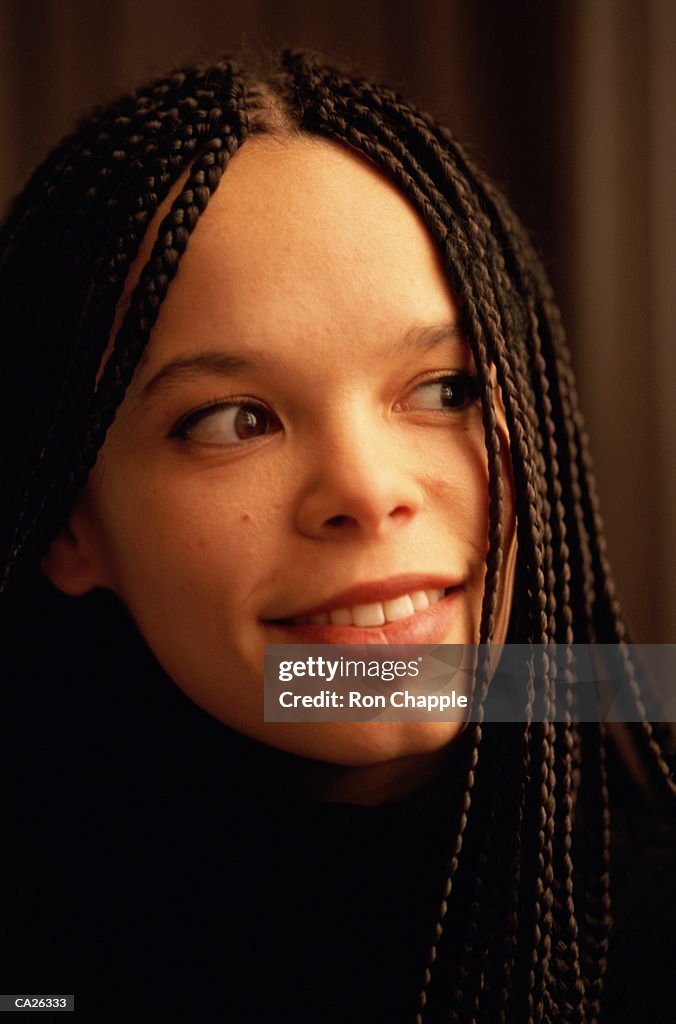 Young woman with braided hair smiling, close-up