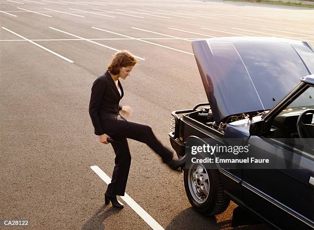 woman kicking tire on car, profile (blurred motion) - kicking tire stock pictures, royalty-free photos & images