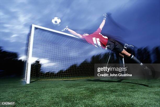 goalkeeper making diving save (blurred motion) - making a save sports stock-fotos und bilder