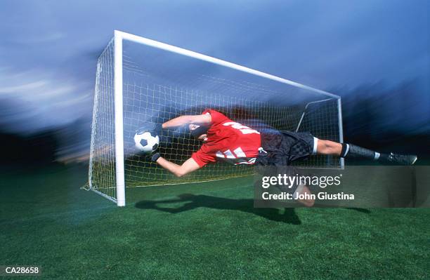 soccer goalkeeper making diving save - making a save sports stock-fotos und bilder