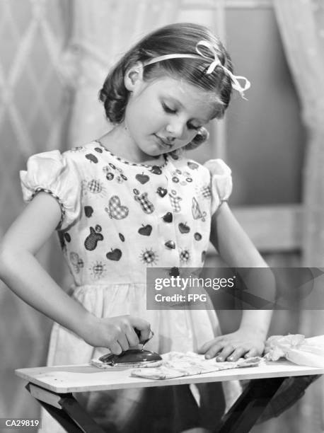 girl (7-9) using toy iron (b&w) - fpg stock pictures, royalty-free photos & images