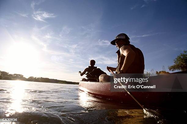 couple canoeing on lake - canoa foto e immagini stock