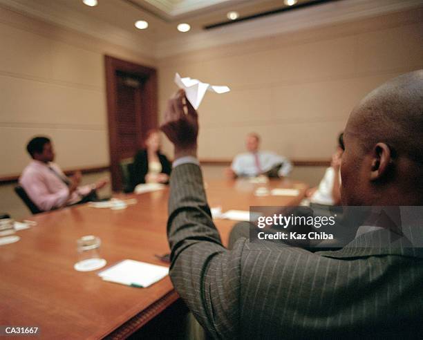 businessman aiming paper aeroplane in meeting room, rear view - desk toy 個照片及圖片檔