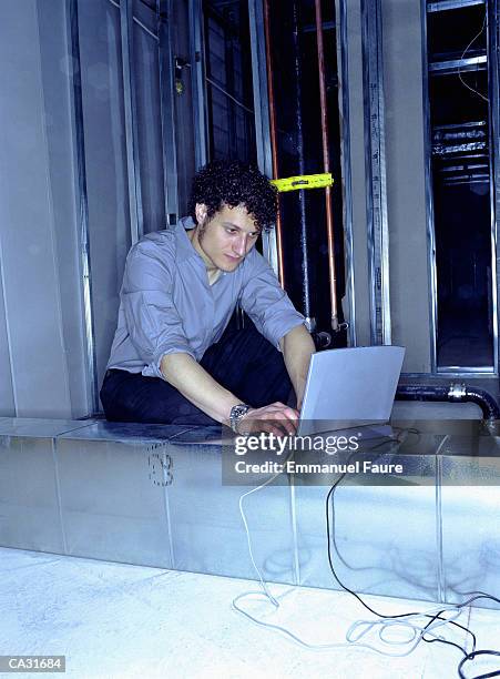 young man using laptop in office under reconstruction - installation of memorial honors victims of ghost ship fire in oakland stockfoto's en -beelden