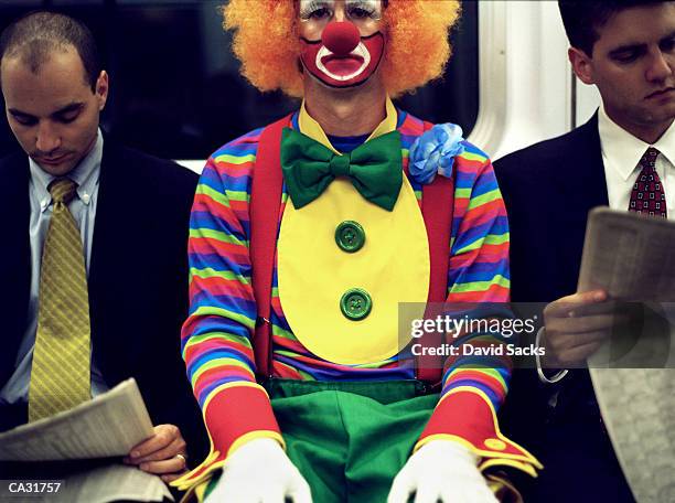 clown riding subway between two businessmen, close-up - clown imagens e fotografias de stock