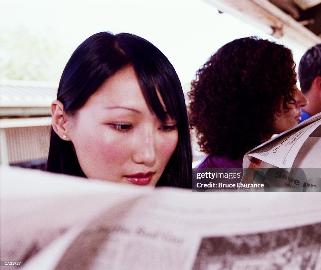 Commuters reading newspapers