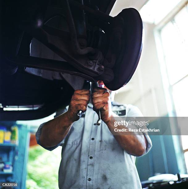 auto mechanic working on car on lift - chassis stock pictures, royalty-free photos & images