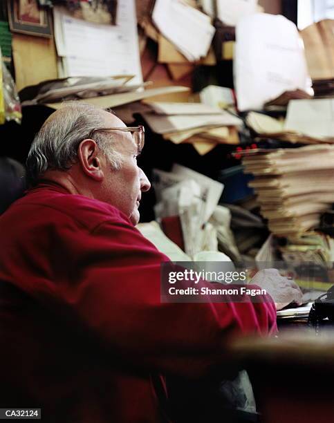 mature man at desk, surrounded by piles of paperwork - shannon stock pictures, royalty-free photos & images