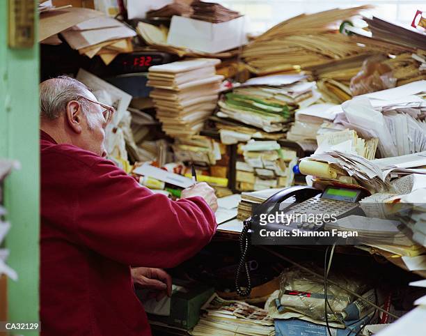 mature man in front of pile of papers - shannon stock pictures, royalty-free photos & images