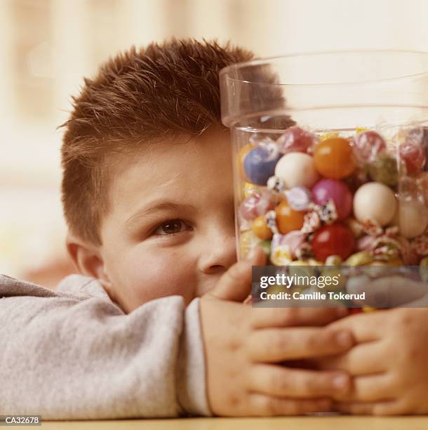 boy (4-6) grabbing candy jar - candy jar stock pictures, royalty-free photos & images