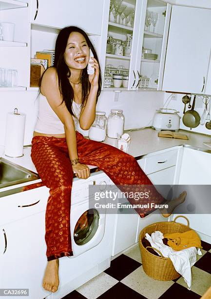 woman sitting on counter using telephone - emmanuel stock pictures, royalty-free photos & images