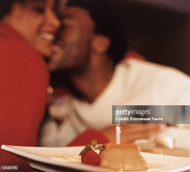 young couple snuggling in cafe (focus on candle in foreground) - emmanuel stock pictures, royalty-free photos & images