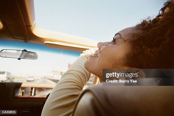 woman riding in car, looking through sunroof - sunroof stock pictures, royalty-free photos & images