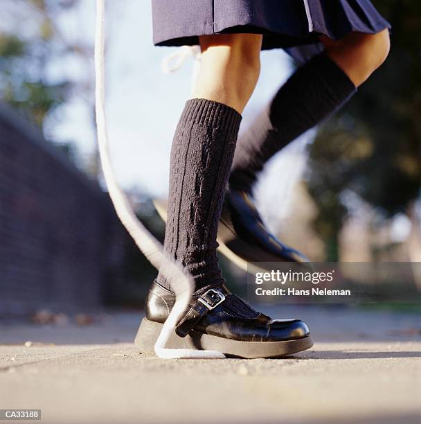 girl jumping rope outdoors, low section - hans neleman stockfoto's en -beelden