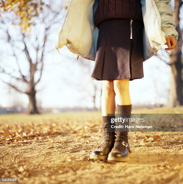 schoolgirl holding kite in autumn, low section - hans neleman stockfoto's en -beelden