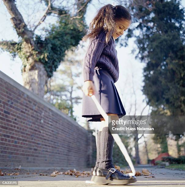 girl (6-8) playing jumprope on sidewalk in autumn - hans neleman stockfoto's en -beelden