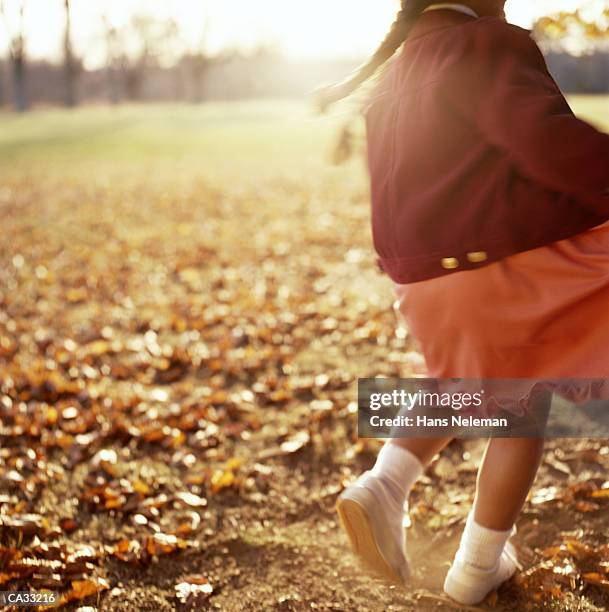 girl (8-10) playing outdoors in autumn, rear view - hans neleman stockfoto's en -beelden