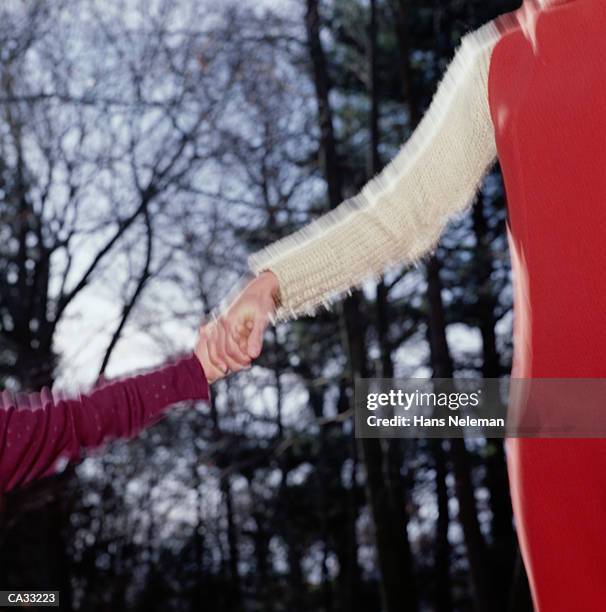 mother and daughter holding hands outdoors in autumn, detail - hans neleman stockfoto's en -beelden